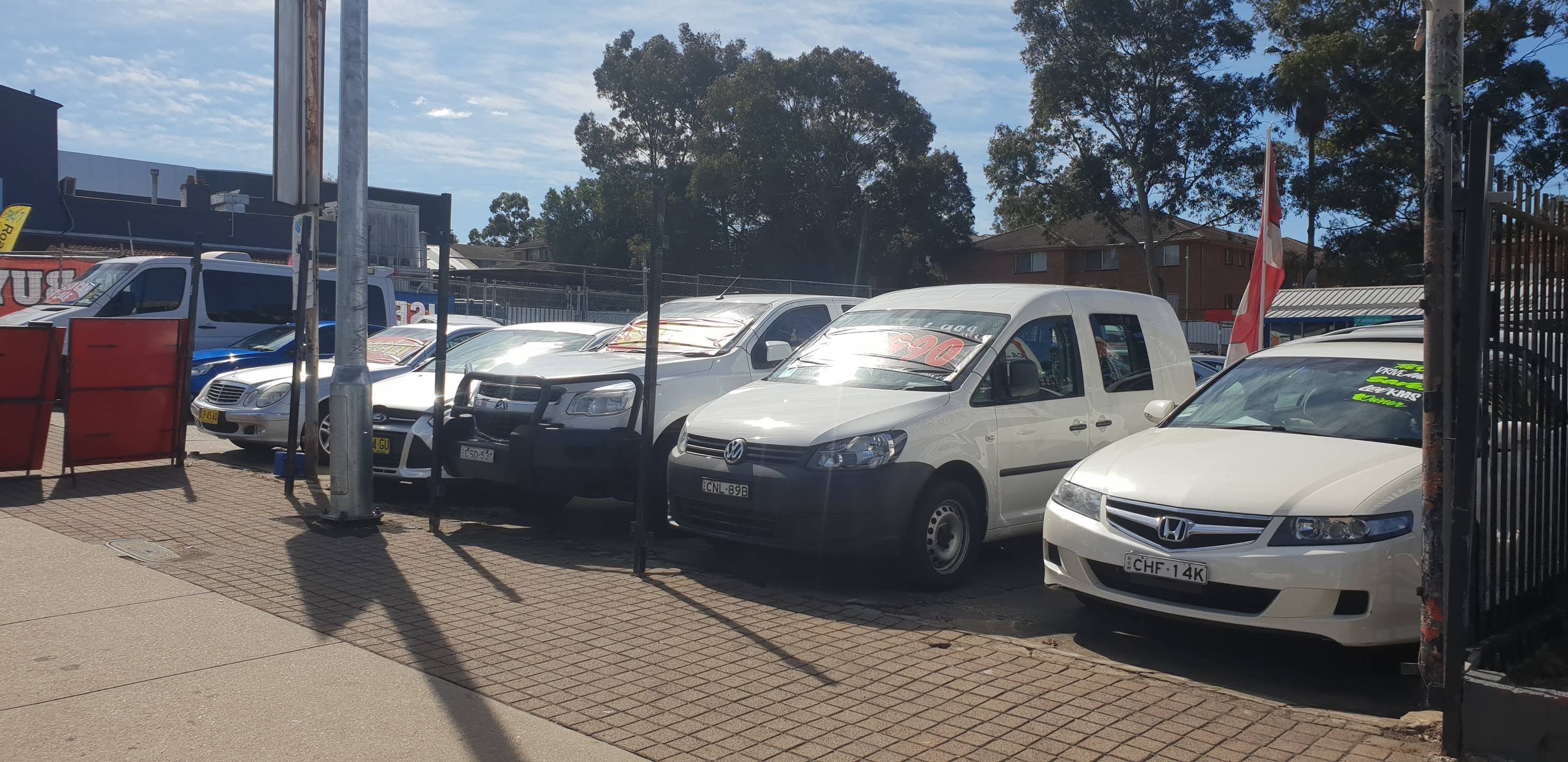The kerbside row at Auto Alley: a white Honda Accord Euro, a Volkswagen Caddy van and a Toyota HiLux with a bullbar